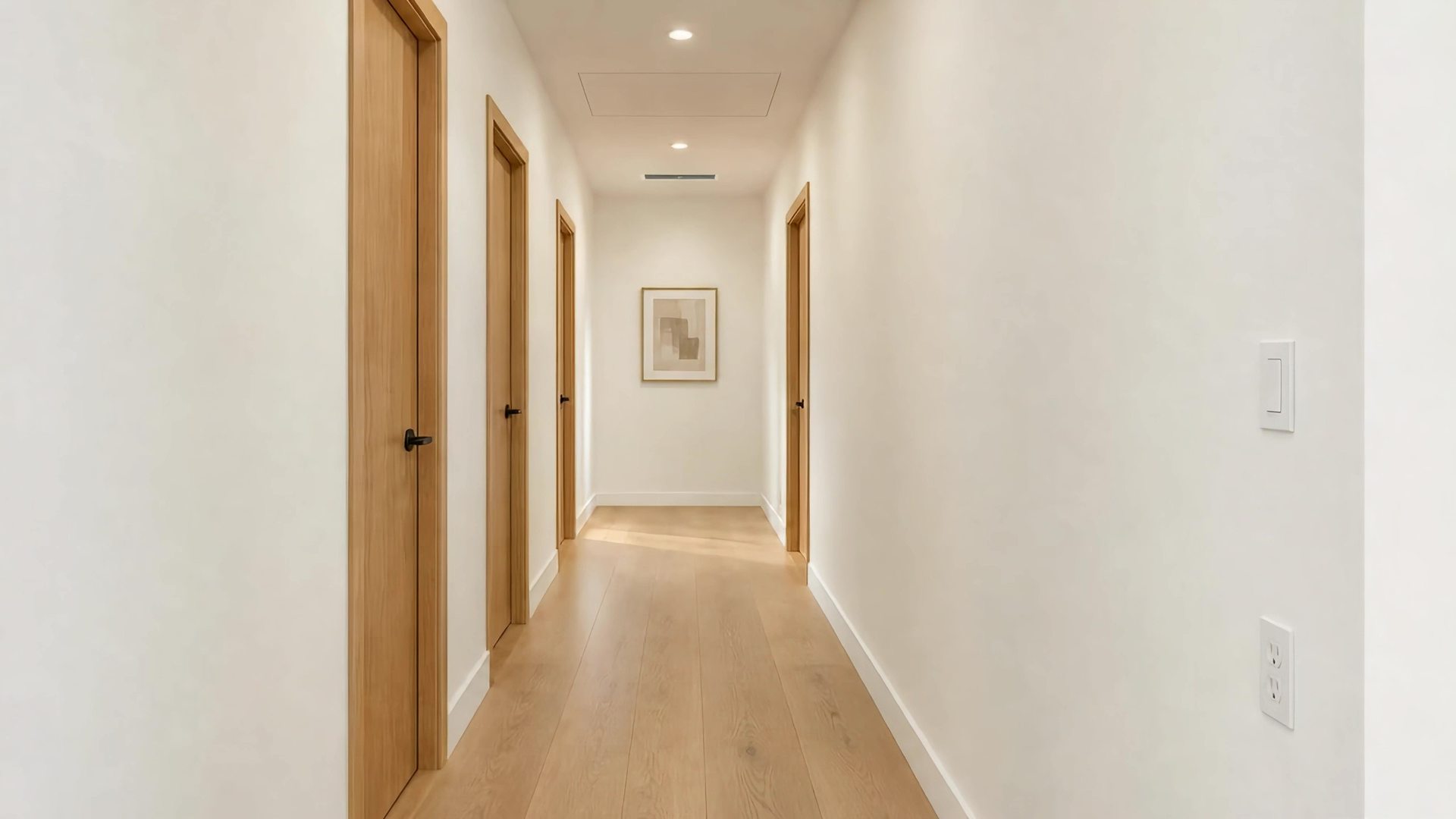 The hallway finished: lights on, walls painted, doors in place